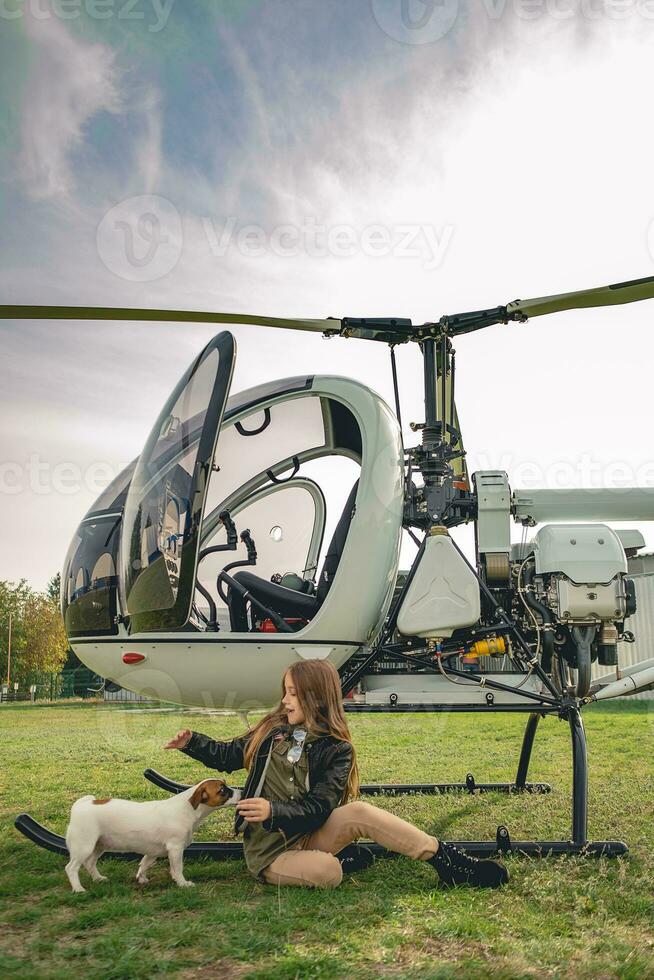 vrolijk tween meisje spelen met puppy in de buurt helikopter foto