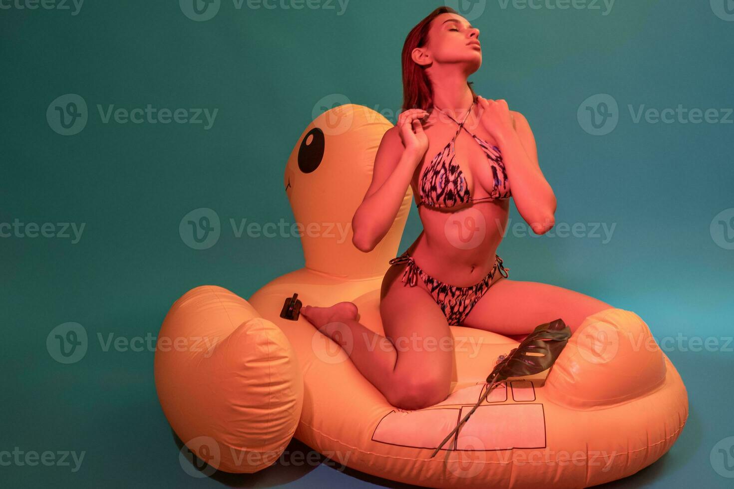 verleidelijk meisje in bikini met Gesloten ogen Aan opblaasbaar zwembad vlotter foto