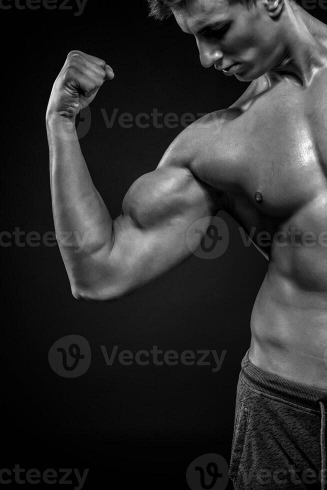 geschiktheid Mens tonen zijn triceps, biceps spieren Aan zwart backgro foto