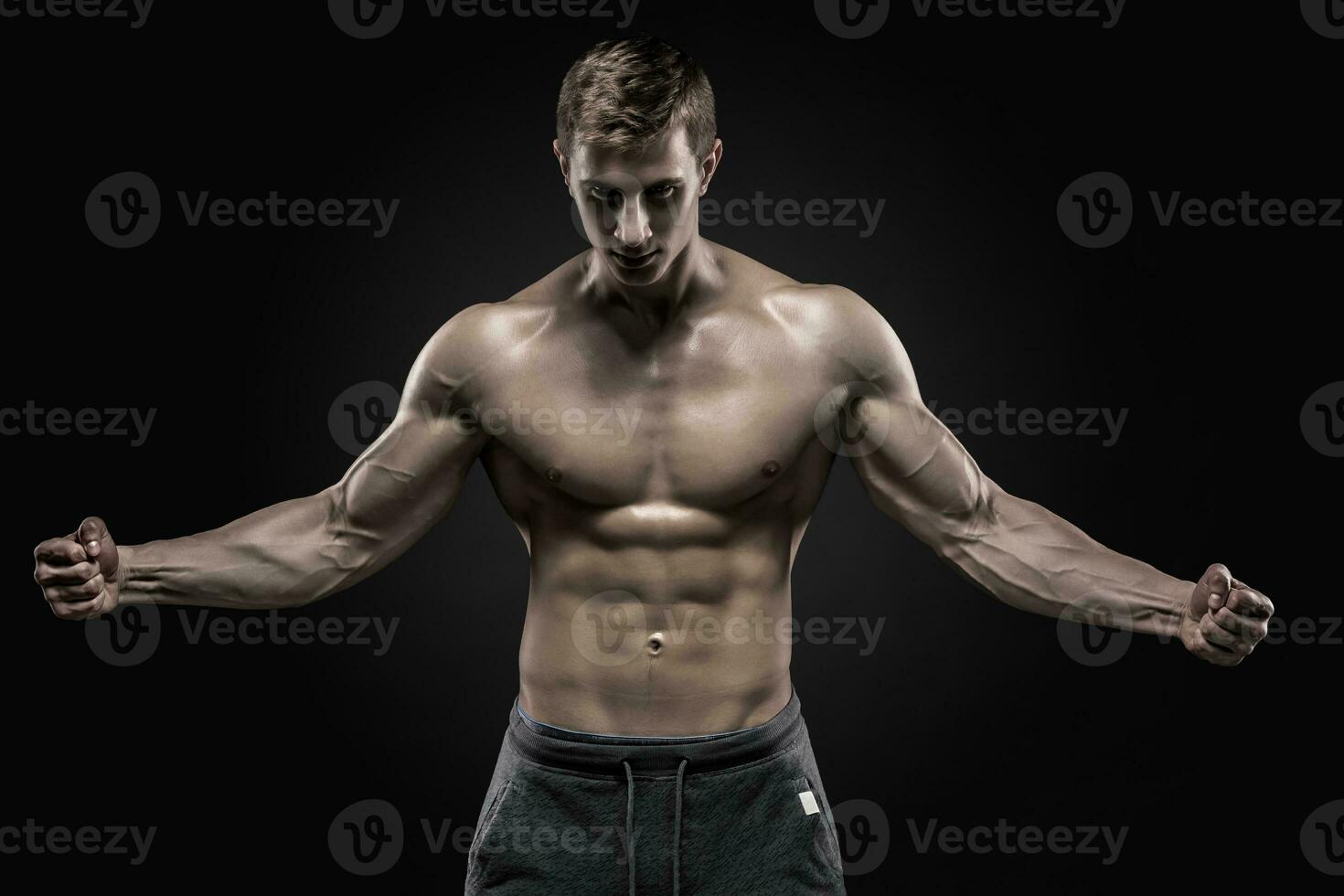 verbijsterend gespierd Mens tonen perfect buikspieren, schouders, biceps, triceps, borst foto