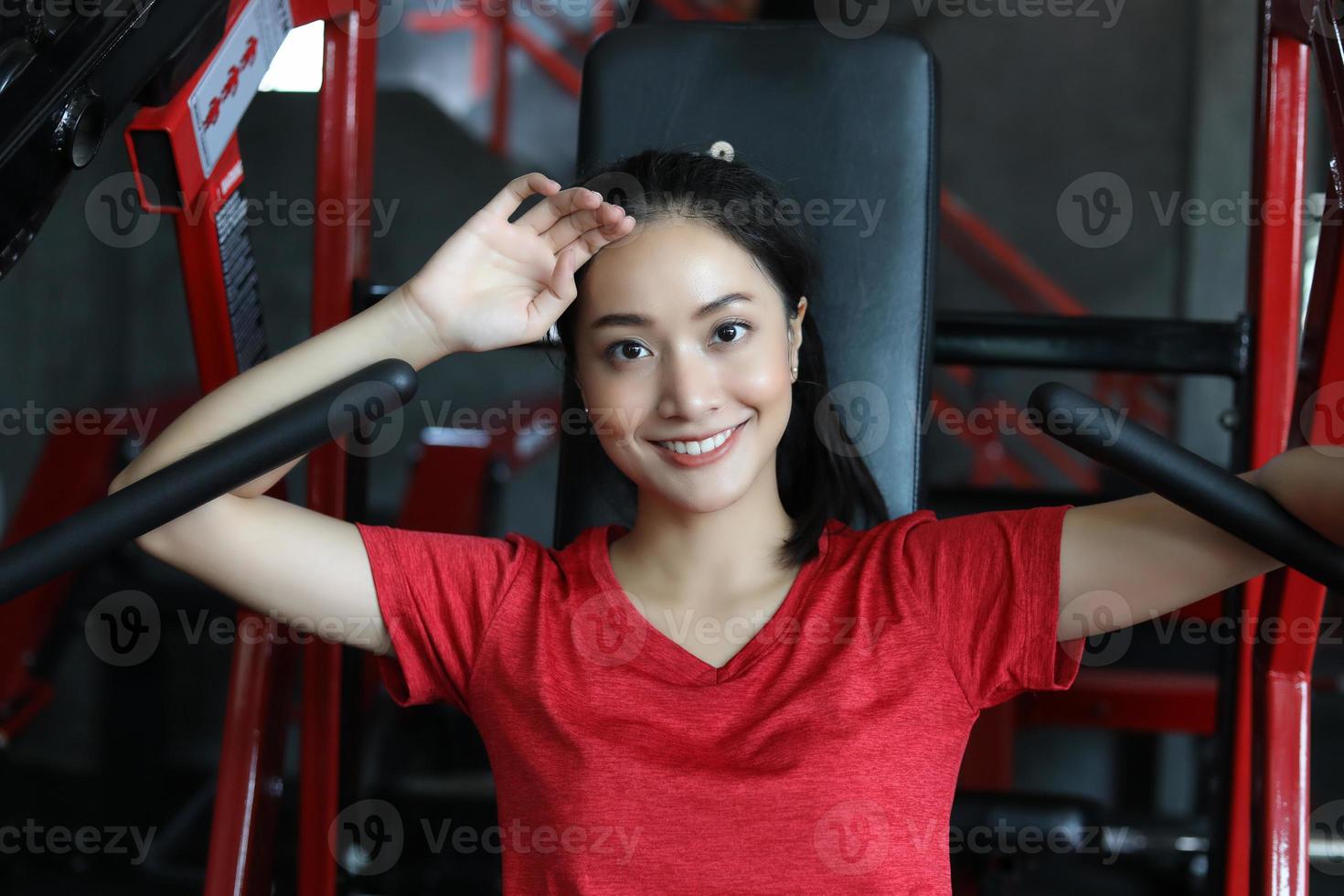 mooie gespierde fitte vrouw die spieren bouwt en fitness vrouw die oefeningen doet in de sportschool. fitness - concept van gezonde levensstijl foto