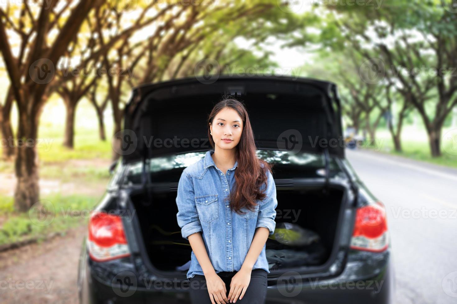 gestresste vrouwen na autopech met rode driehoek van een auto op de weg foto