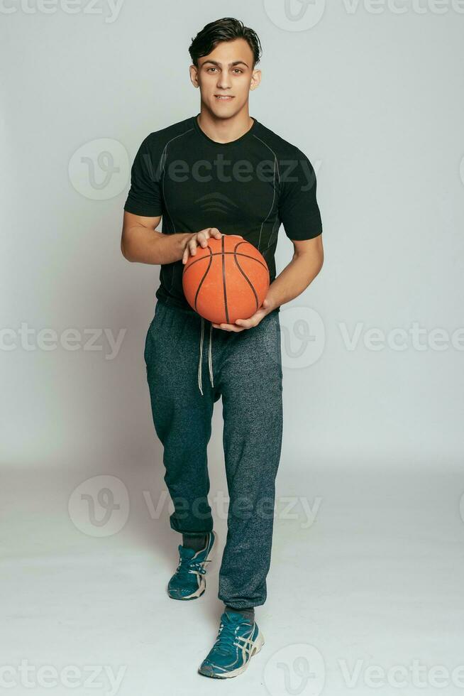 knap jong glimlachen Mens draag- een basketbal bal foto