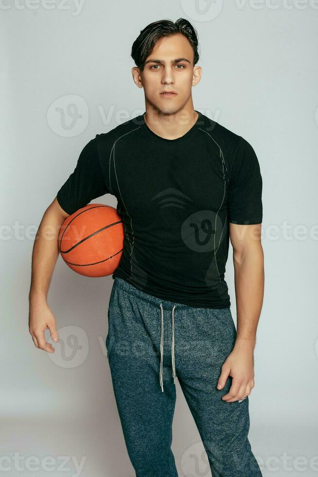 knap jong glimlachen Mens draag- een basketbal bal foto