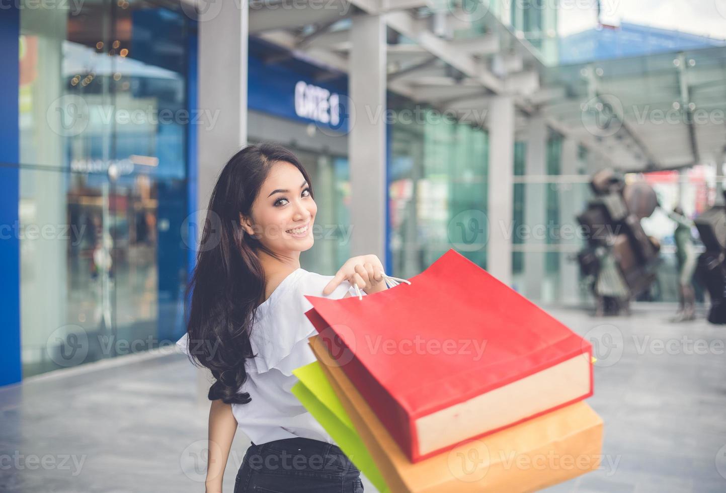 Aziatische vrouwen en mooi meisje houden boodschappentassen vast terwijl ze winkelen in de supermarkt foto