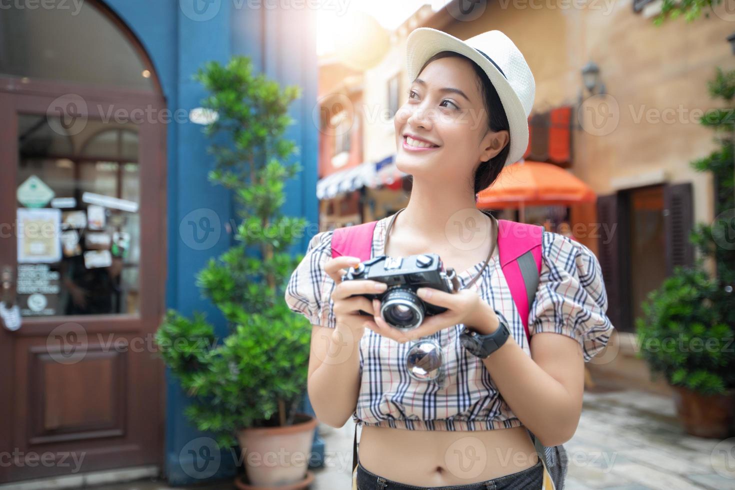 aziatische vrouwen dragen een geruit hemd en rugzakken die samen lopen en gelukkig nemen foto's en selfies, ontspannen tijd op vakantieconceptreizen foto