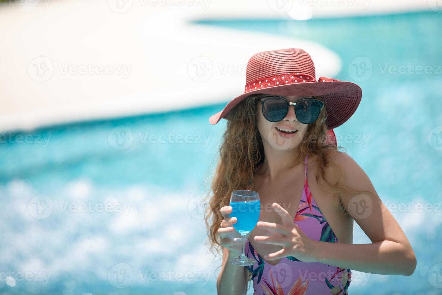 vrouwen dragen bikini's en drinken cocktails in de hete zomer bij het zwembad. foto