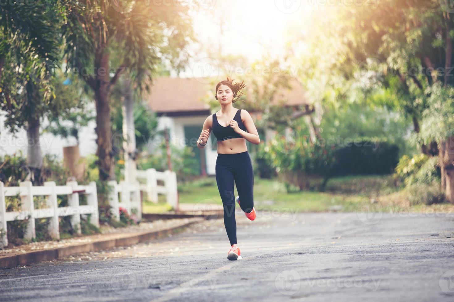 rennende vrouw. vrouwelijke hardloper joggen tijdens buiten op weg .young gemengd ras meisje joggen foto