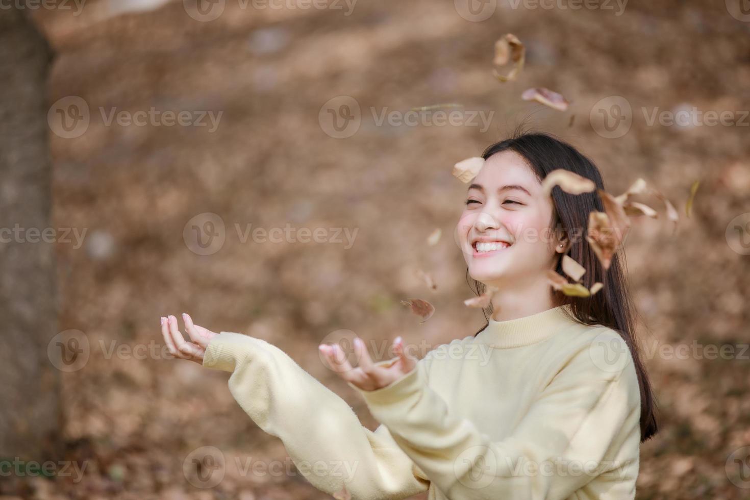 mooie aziatische vrouw die een gelukkig meisje glimlacht en warme kleding winter- en herfstportret draagt in de buitenlucht in het park foto