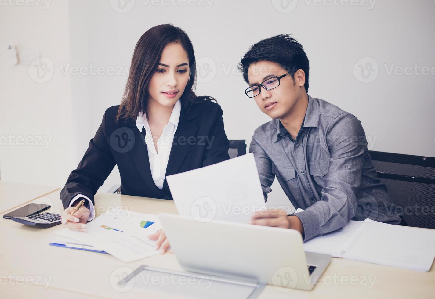 Aziatische zakenlieden en groep die notebook gebruiken voor zakenpartners die documenten en ideeën bespreken tijdens vergaderingen en zakenvrouwen die blij glimlachen om te werken foto