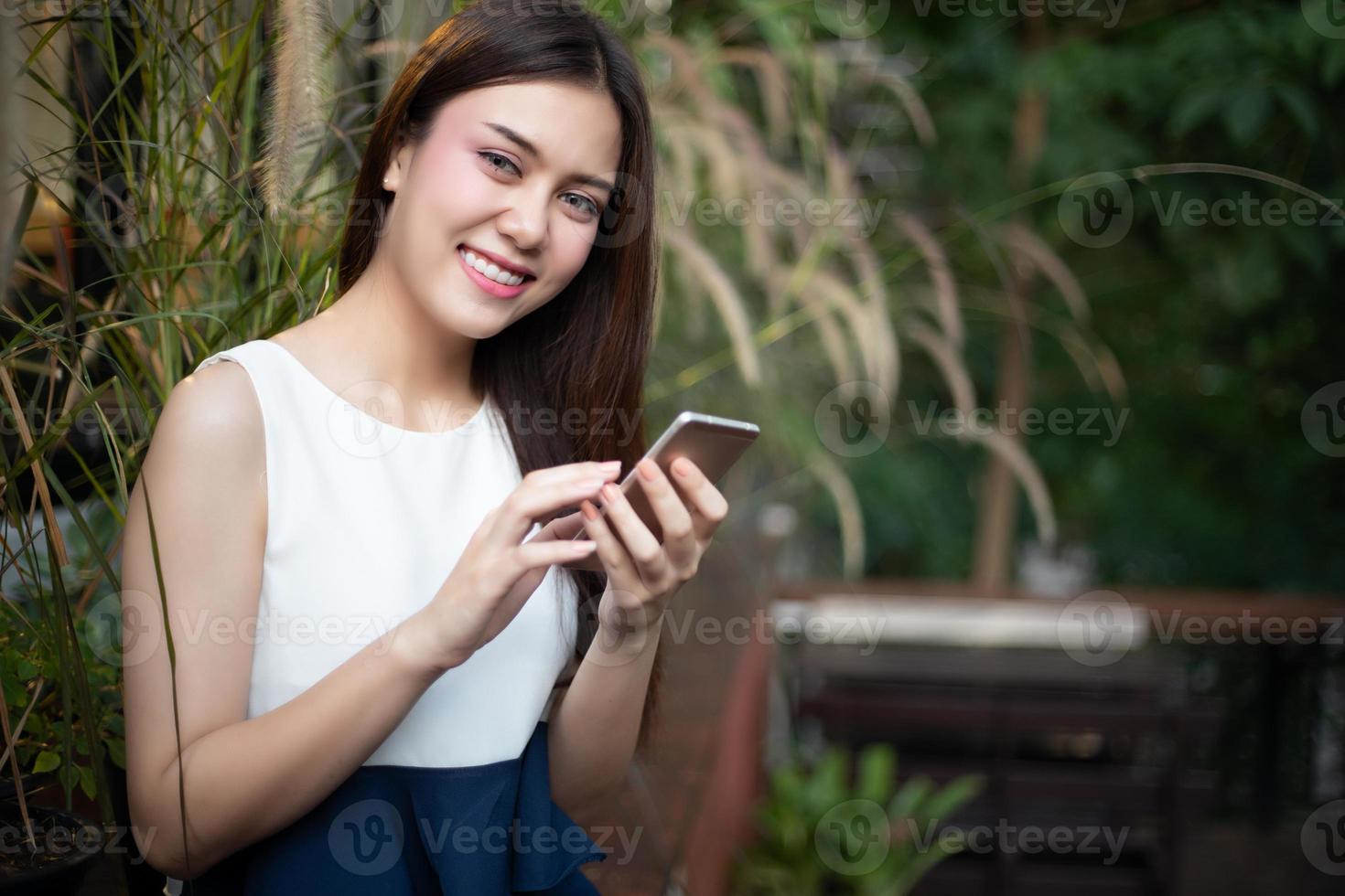 Aziatische zakenlieden en vrouwen gebruiken mobiele telefoons en raken smartphones aan voor communicatie en het controleren van zakenmensen op kantoorachtergrond foto