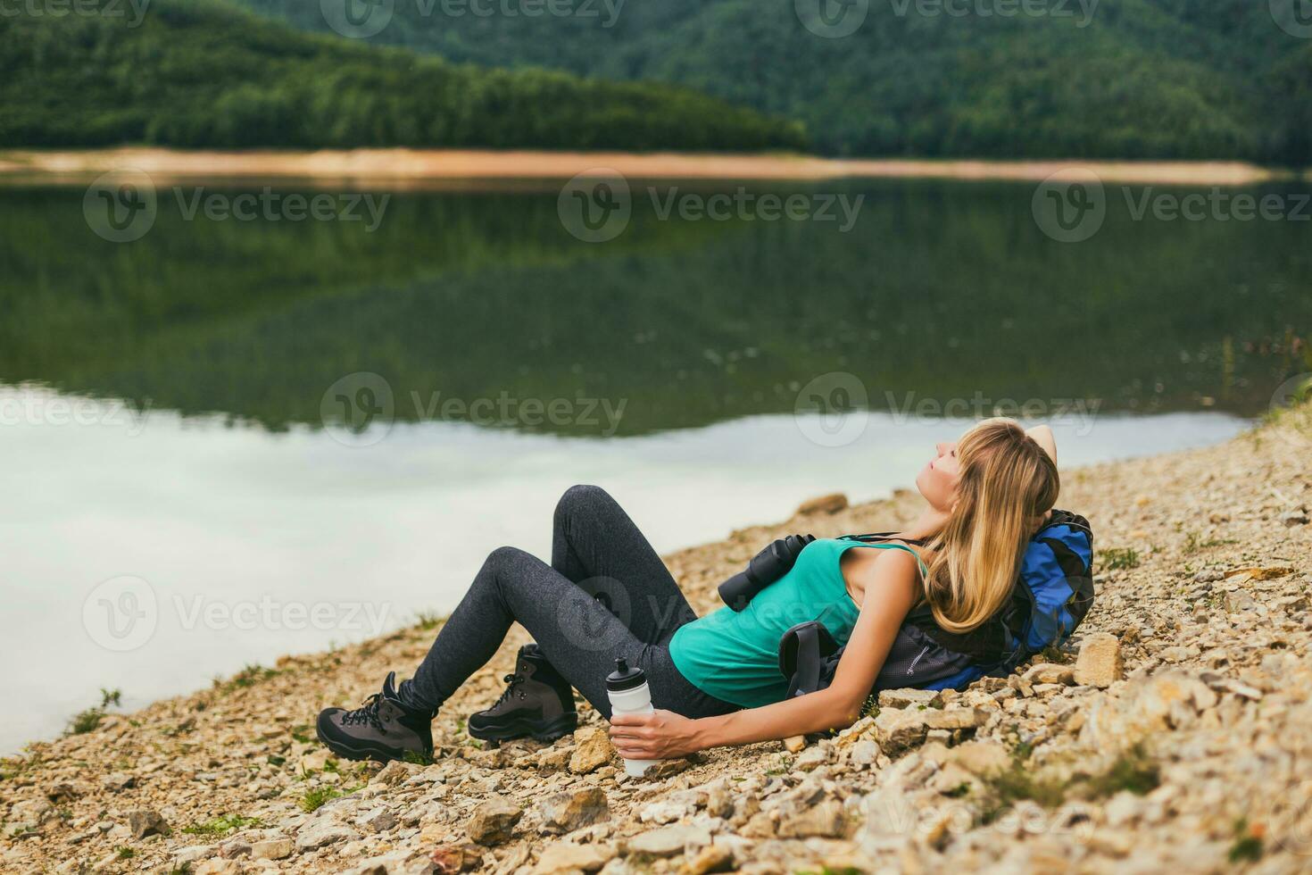 vrouw wandelaar geniet resting door de meer. foto