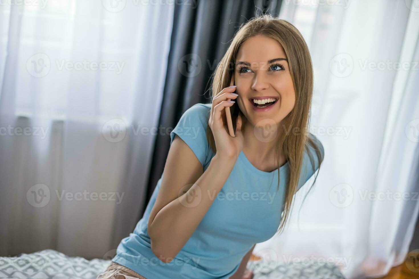 mooi vrouw gebruik makend van telefoon terwijl resting in slaapkamer. foto
