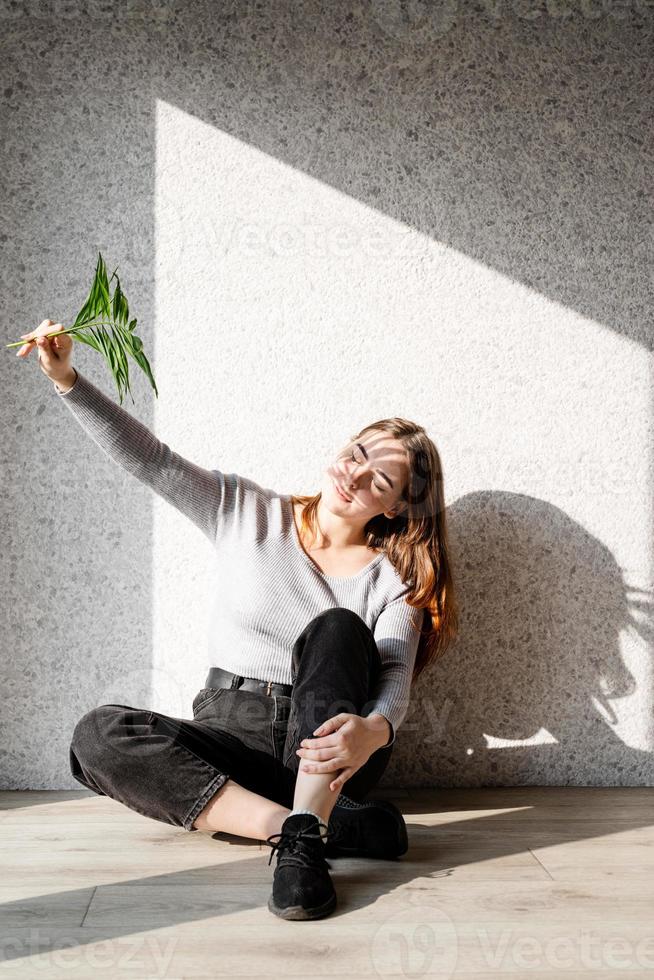 portret van een mooie jonge vrouw met een schaduwpatroon op het gezicht en lichaam in de vorm van palmblad foto