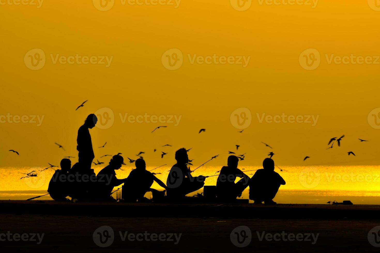 silhouetten van mensen visvangst Aan een meer Bij zonsondergang. foto