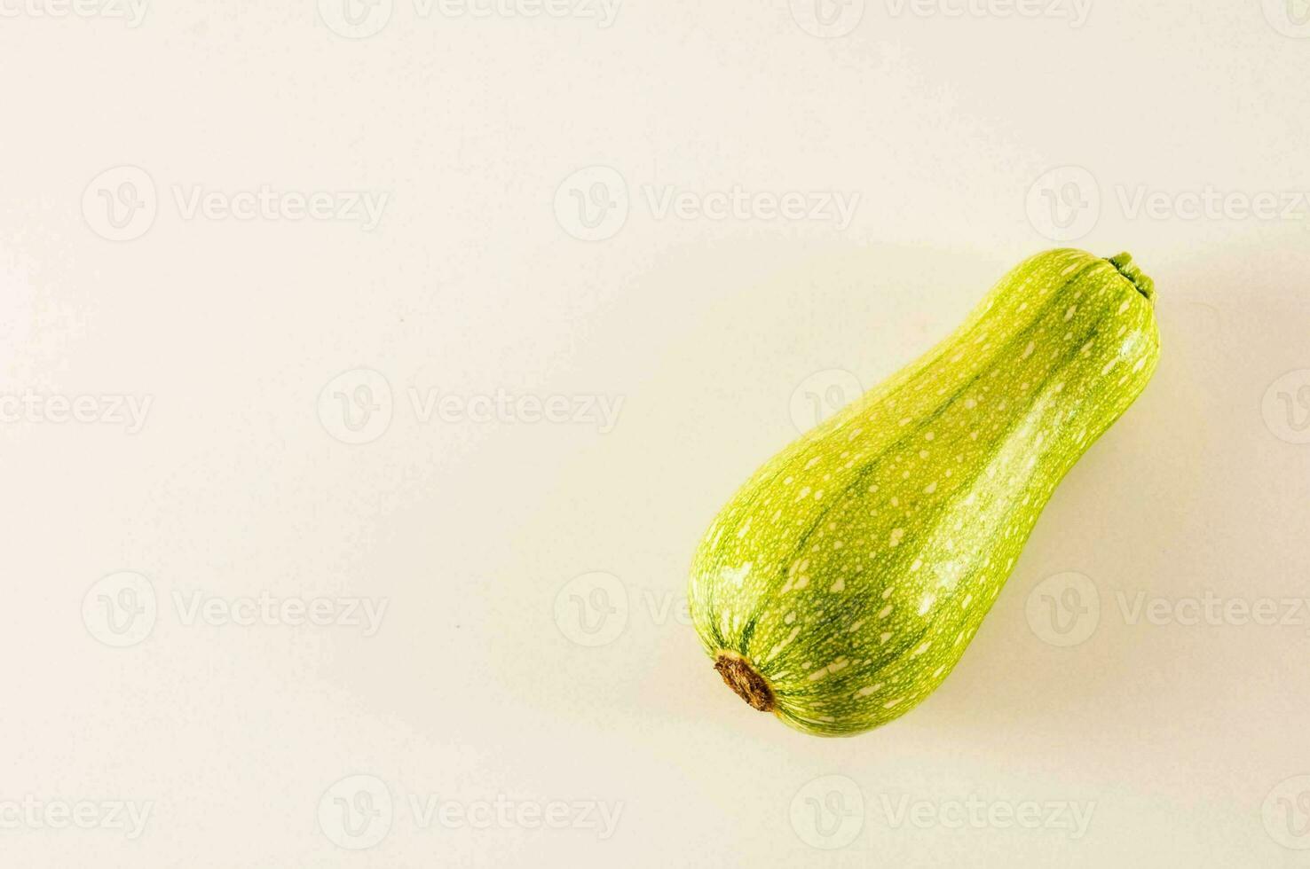 een single groen squash Aan een wit achtergrond foto