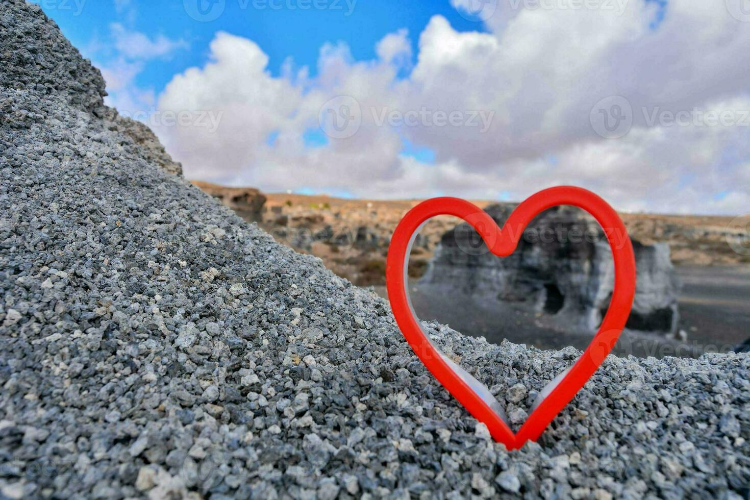 een rood hart vormig rots in de midden- van een rotsachtig landschap foto