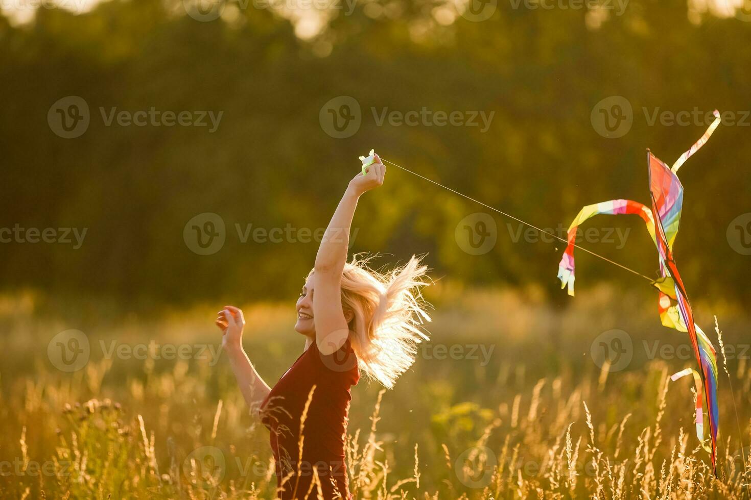 schoonheid meisje rennen met vlieger Aan de veld. mooi jong vrouw met vliegend kleurrijk vlieger over- Doorzichtig blauw lucht. vrij, vrijheid concept. emoties, gezond levensstijl foto