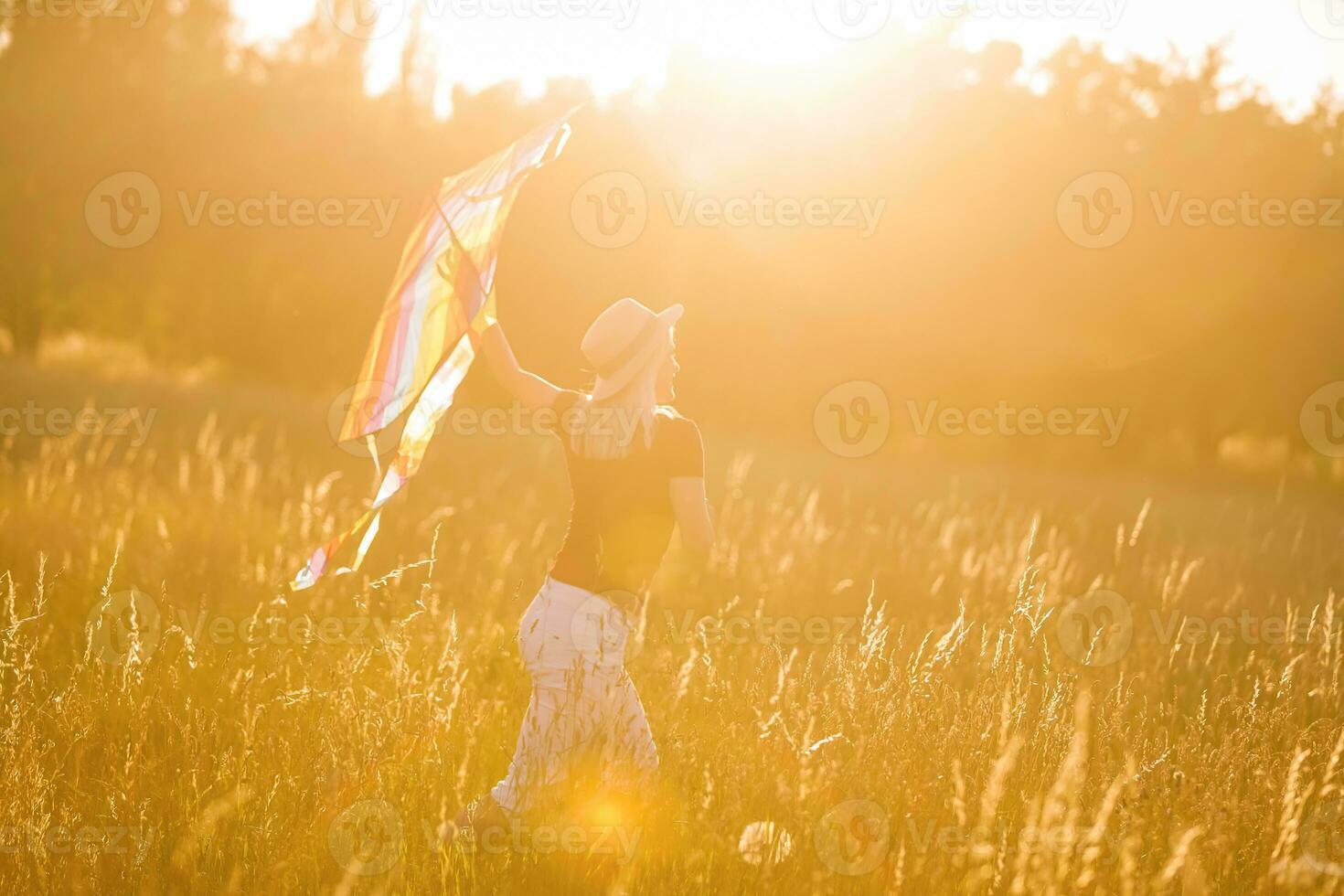 portret van een jong en zorgeloos vrouw lancering vlieger Aan de groenveld. concept van actief levensstijl in natuur foto