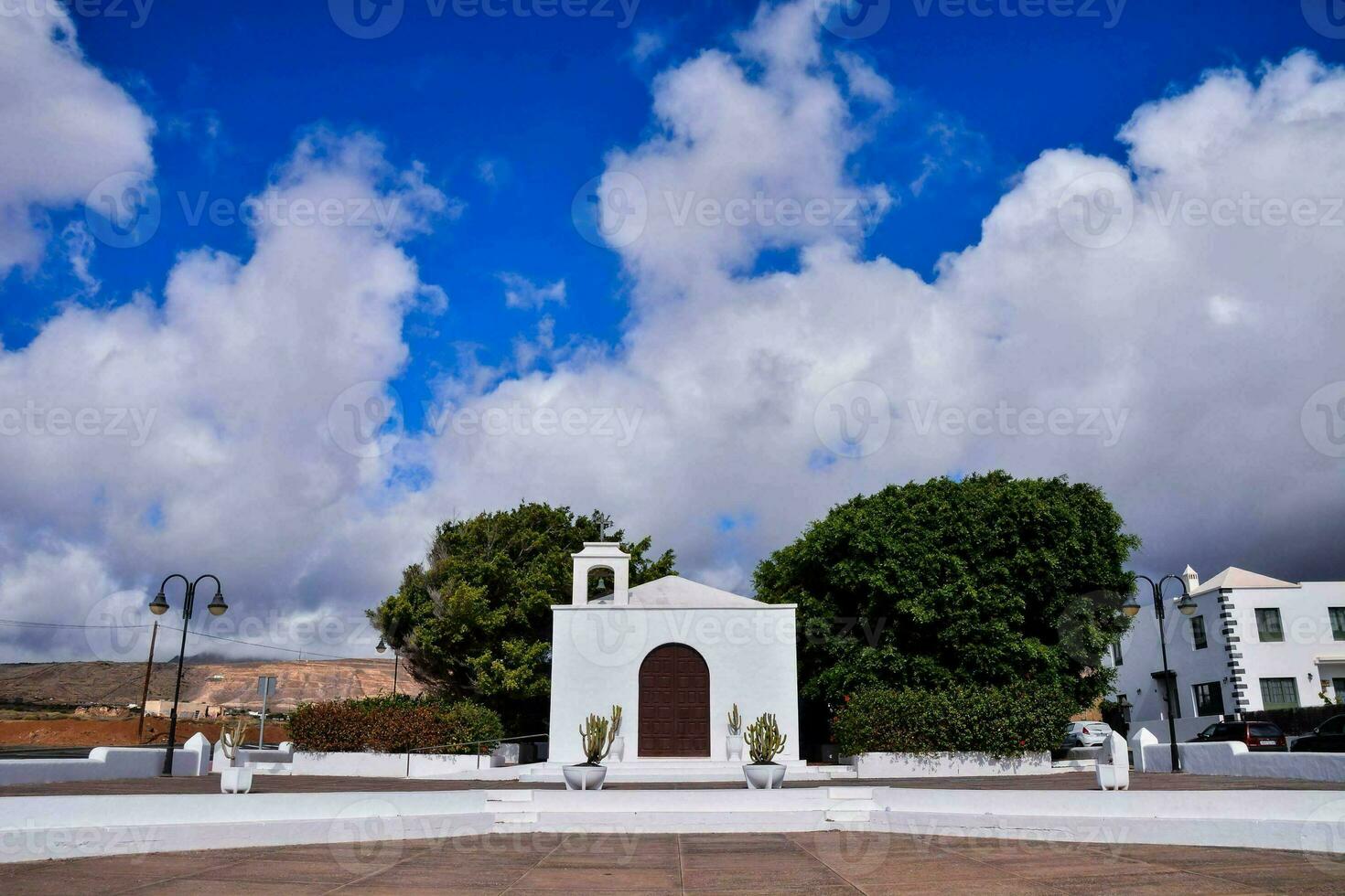 een wit kerk met een blauw lucht en wolken foto