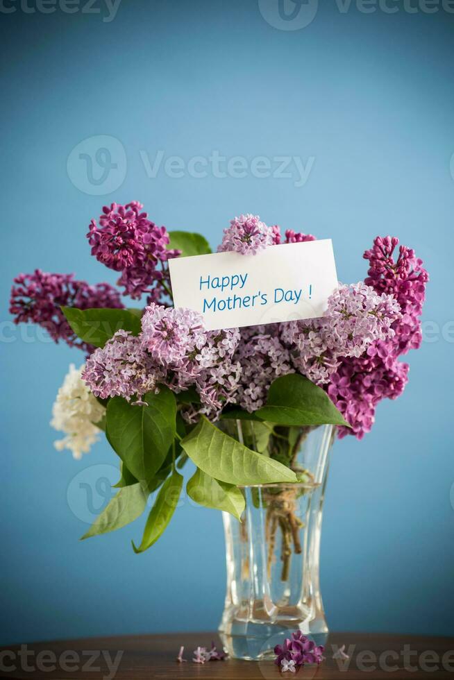 boeket van verschillend bloeiend voorjaar seringen in een vaas Aan blauw achtergrond foto