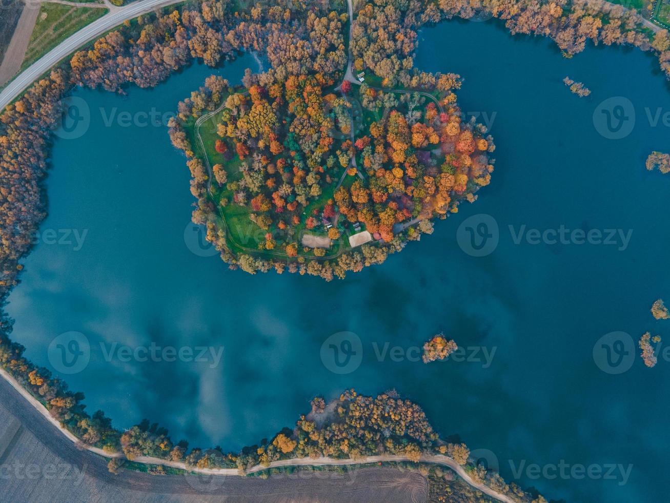 luchtfoto van herfstbos met meerhemel weerspiegeld in water foto
