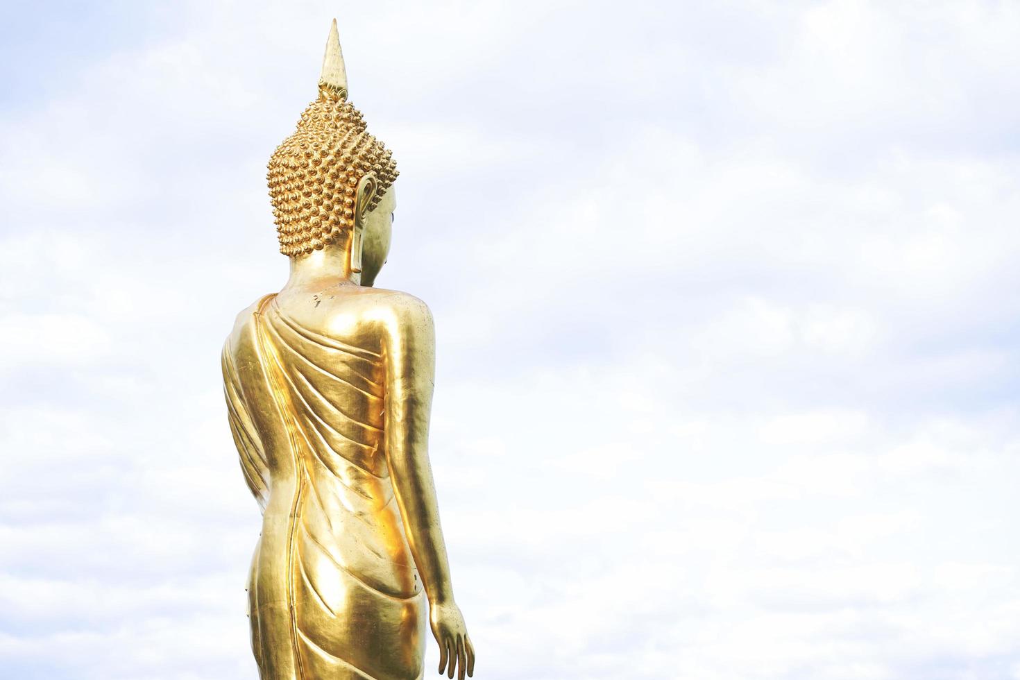 gouden boeddhabeeld staande op een berg, wat phra that khao noi foto