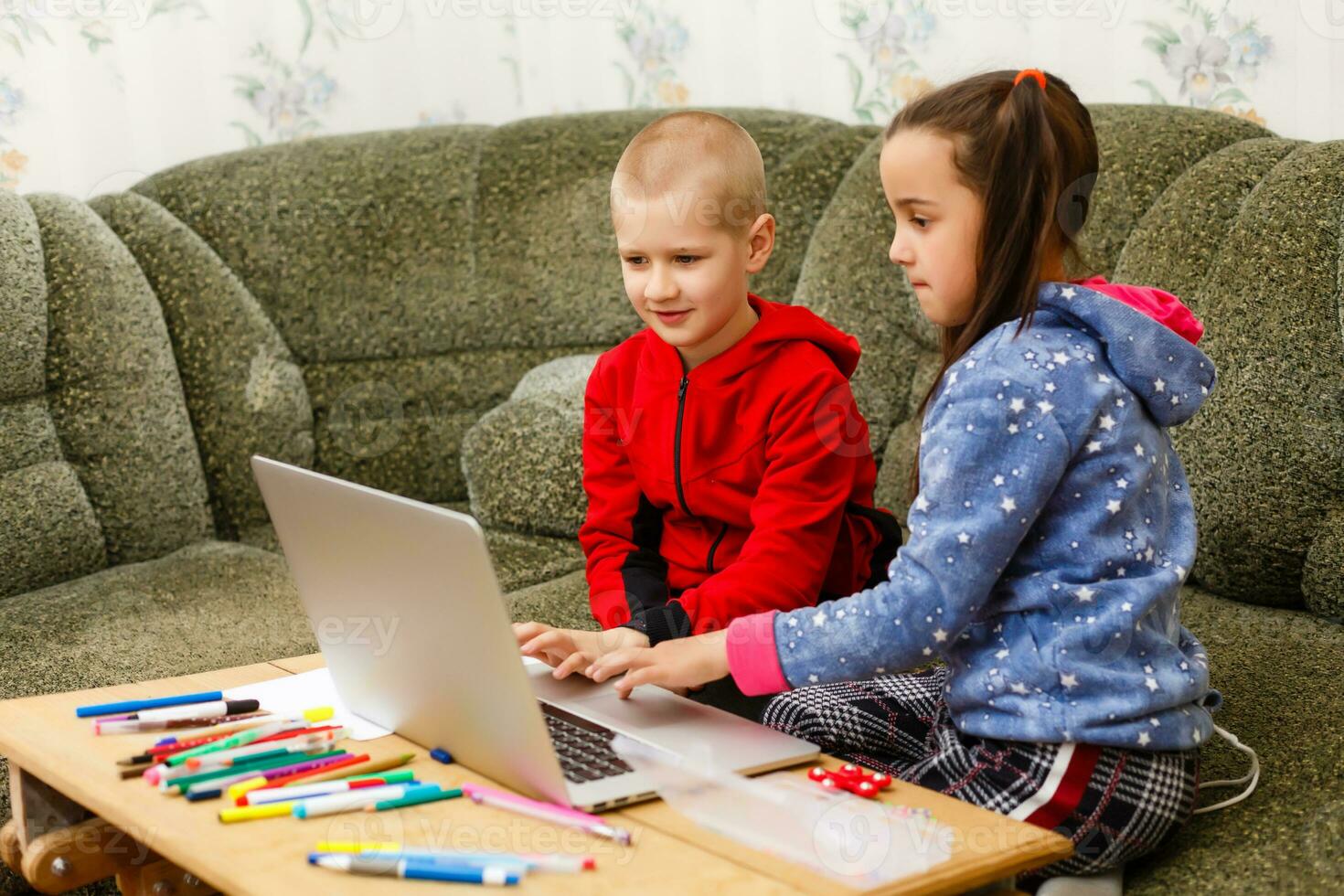 afstand aan het leren online onderwijs. school- jongen en meisje aan het studeren Bij huis met laptop notitieboekje en aan het doen huiswerk. zittend Bij een tafel foto