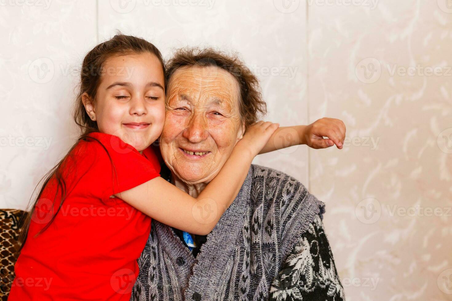 familie bonding concept. lief weinig meisje gelukkig omarmen haar grootmoeder in licht leven kamer foto