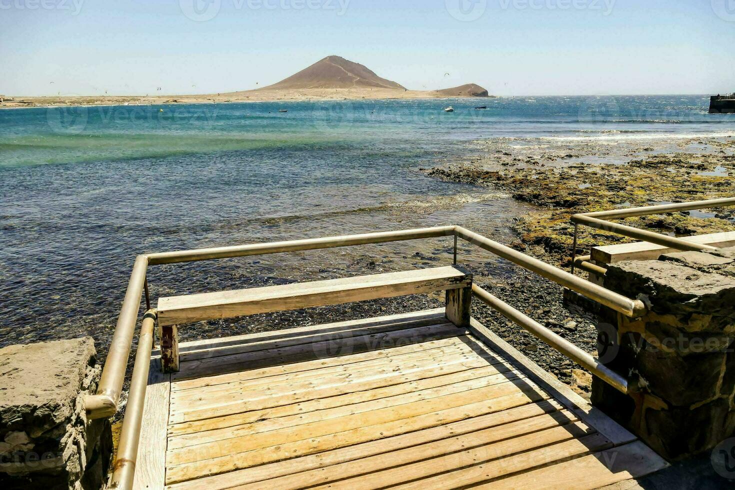 een houten loopbrug Leidt naar de oceaan foto