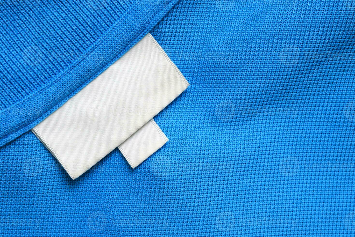 blanco wit wasserij zorg kleren etiket Aan blauw overhemd kleding stof structuur achtergrond foto