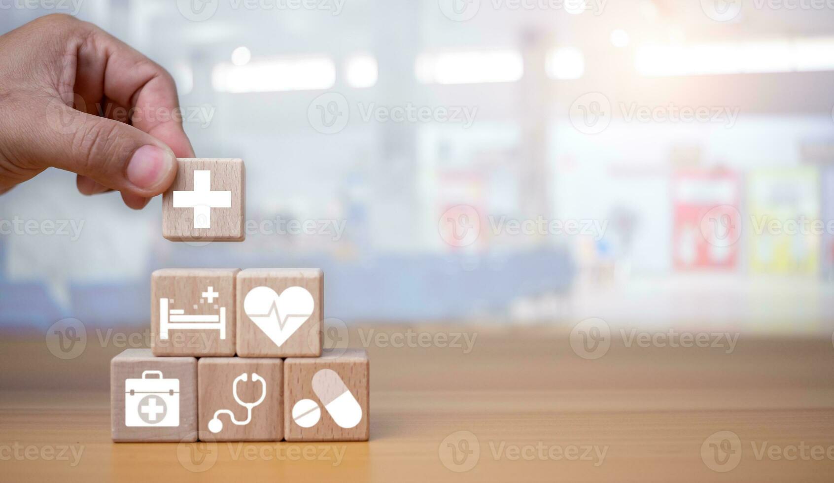 Gezondheid verzekering en gezondheidszorg concept, menselijk hand- houdt houten blok met pictogrammen over Gezondheid verzekering en gezondheidszorg toegang, pensioen planning Aan houten achtergrond. foto