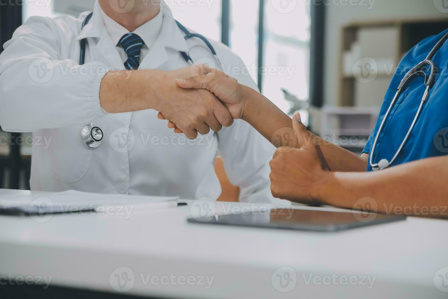 dokter en geduldig beven handen in de kantoor, ze zijn zittend Bij bureau, handen dichtbij omhoog foto