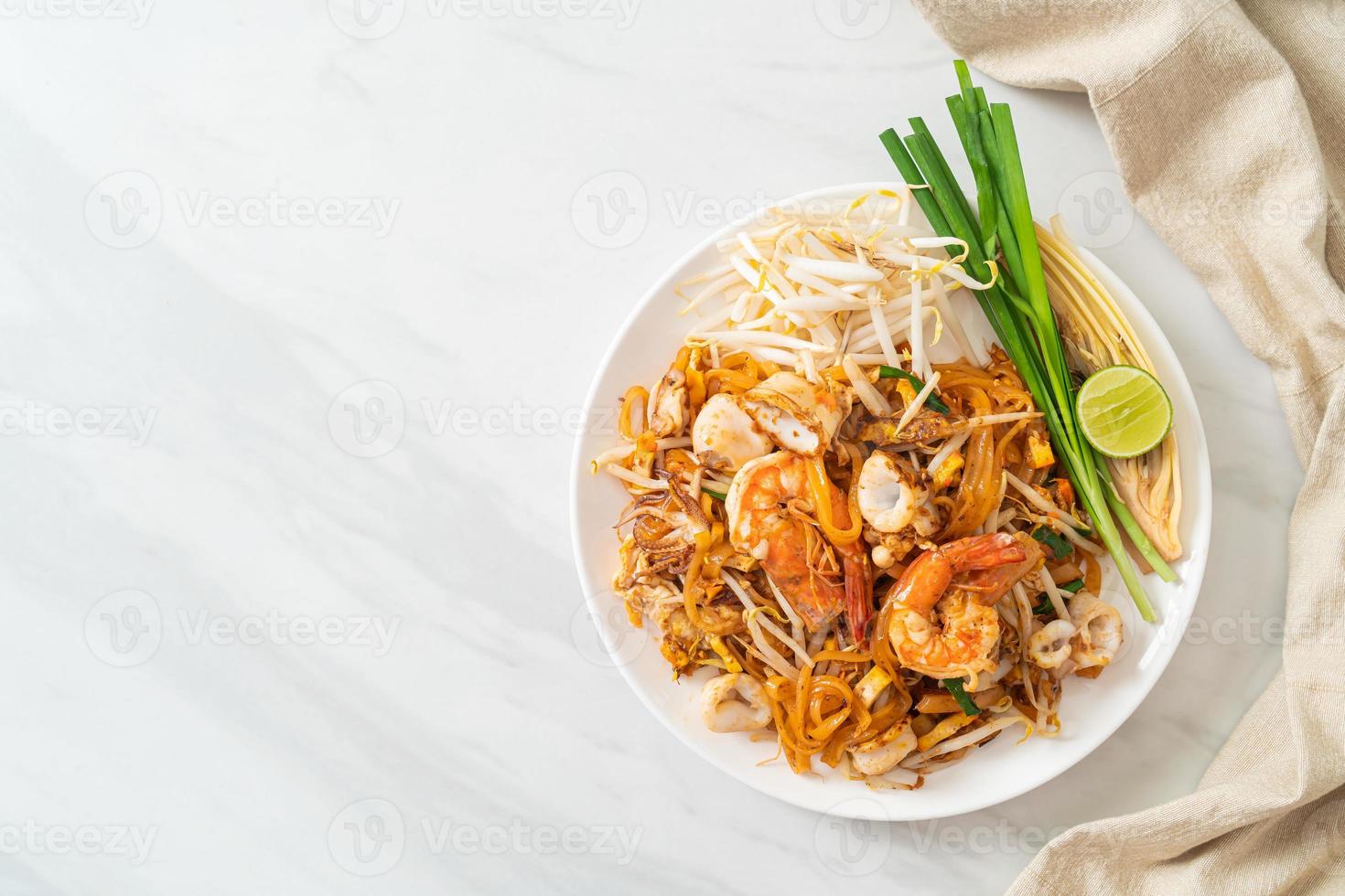pad thai zeevruchten - roergebakken noedels met garnalen, inktvis of octopus en tofu foto
