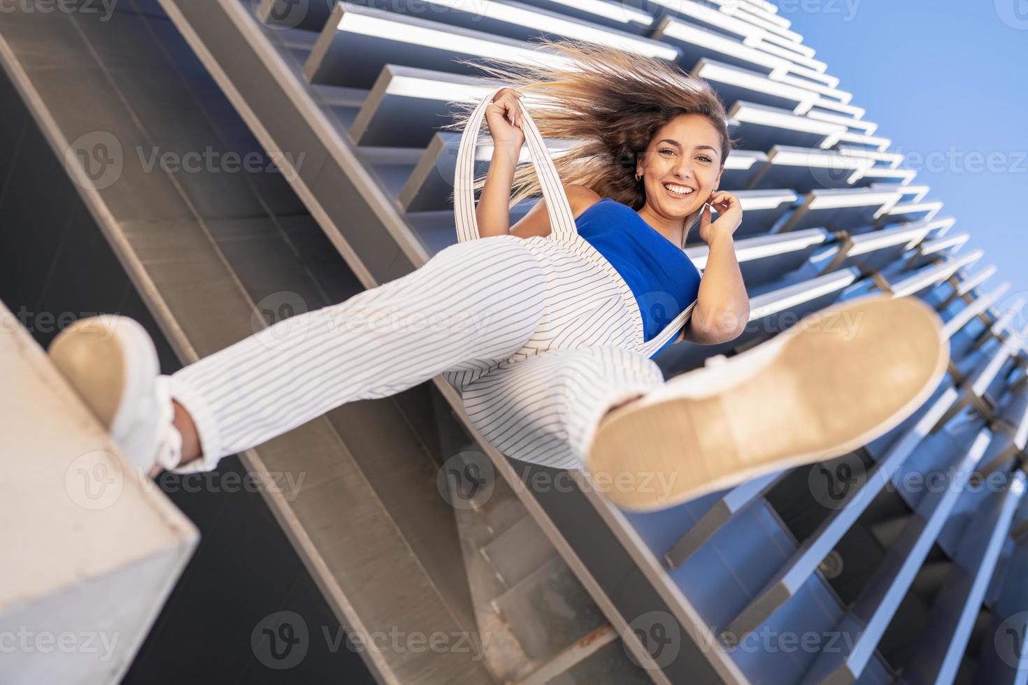 weergave van onderen van een jong meisje dat haar voet in de lucht gooit. foto