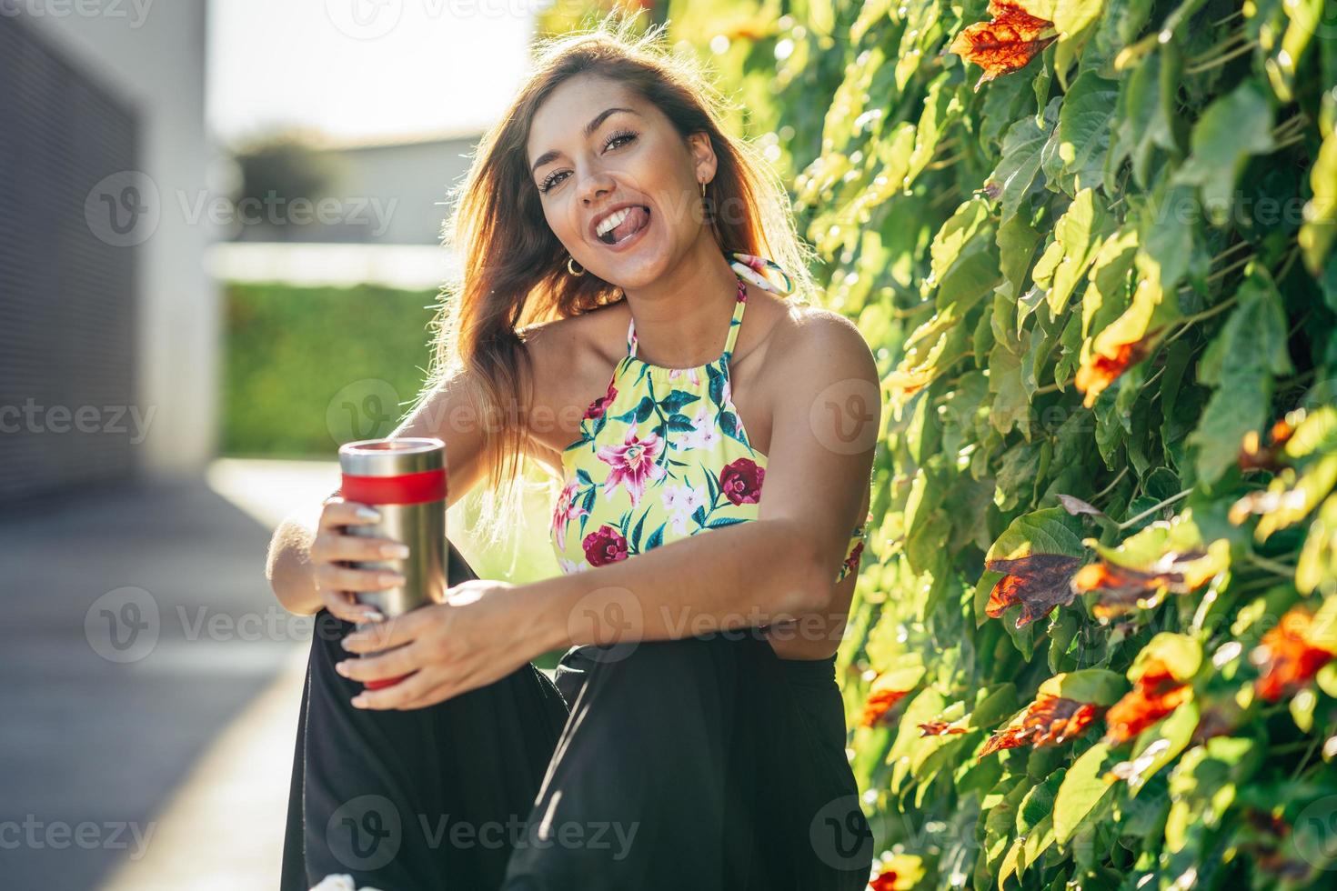 meisje drinkt uit een metalen waterfles in vrijetijdskleding foto