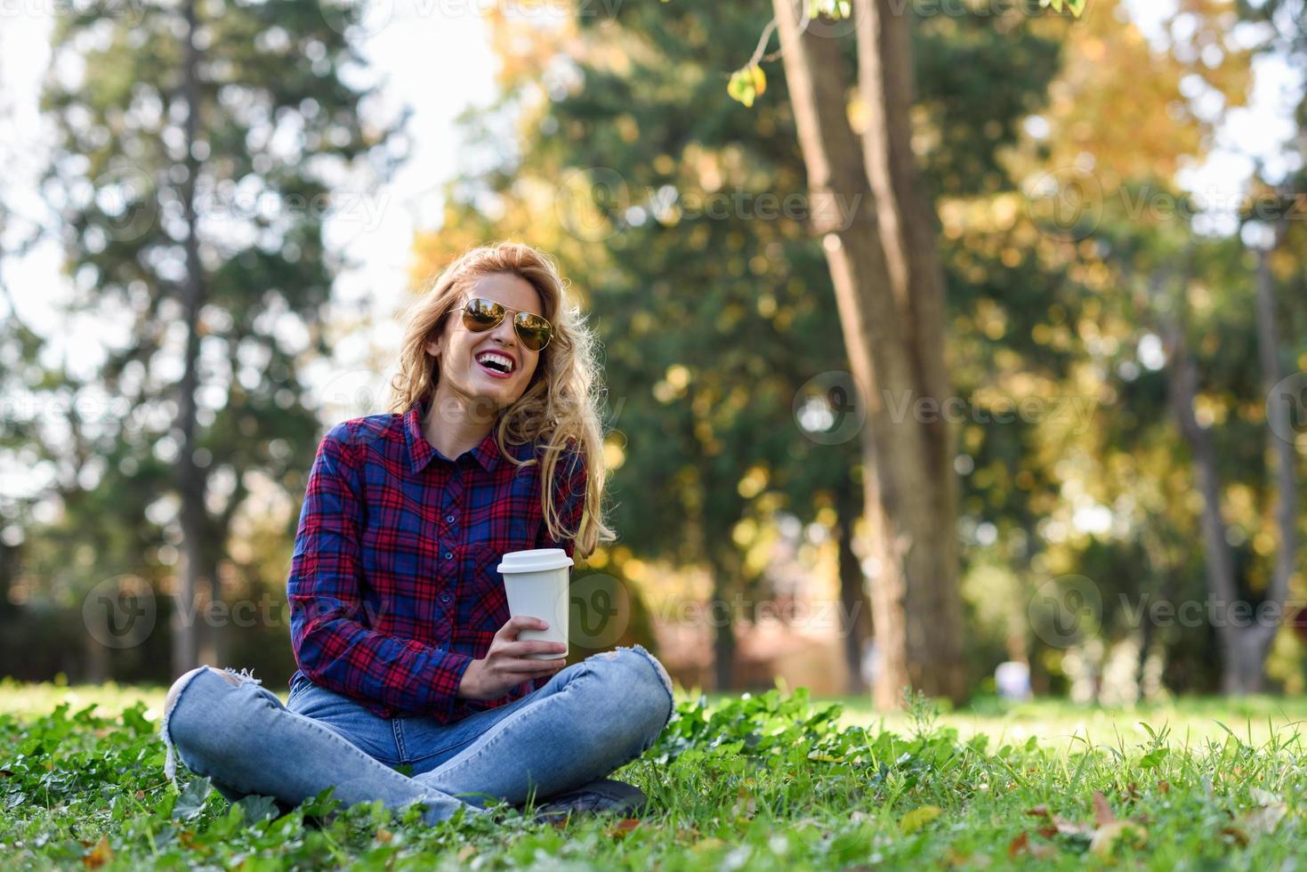 mooie vrouw die koffie drinkt in het park foto