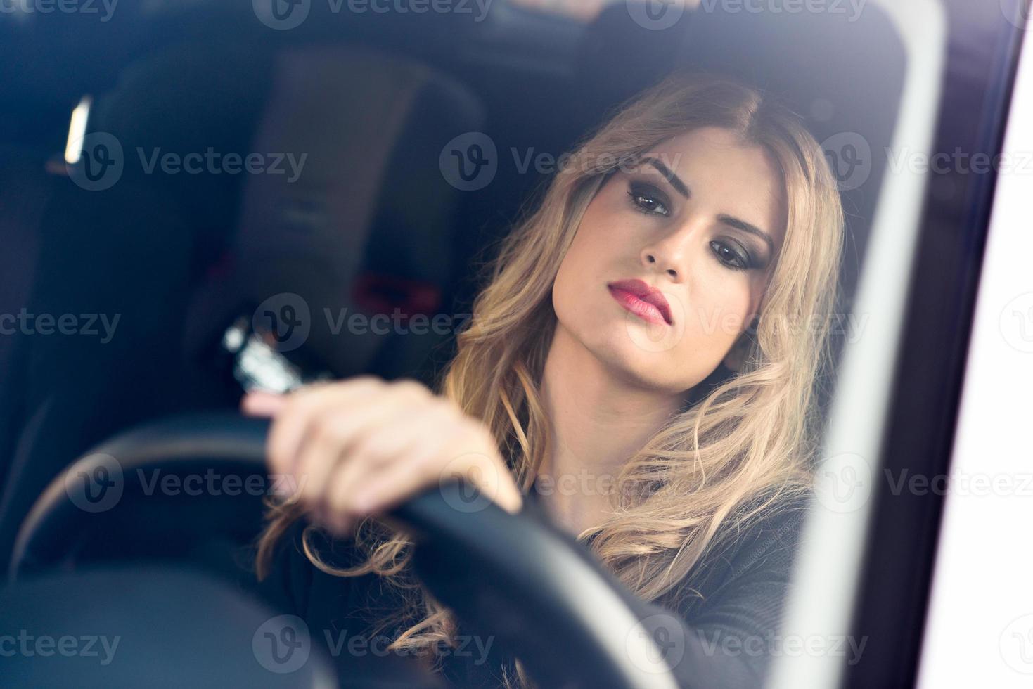 blondie jonge vrouw rijdt in een sportwagen foto