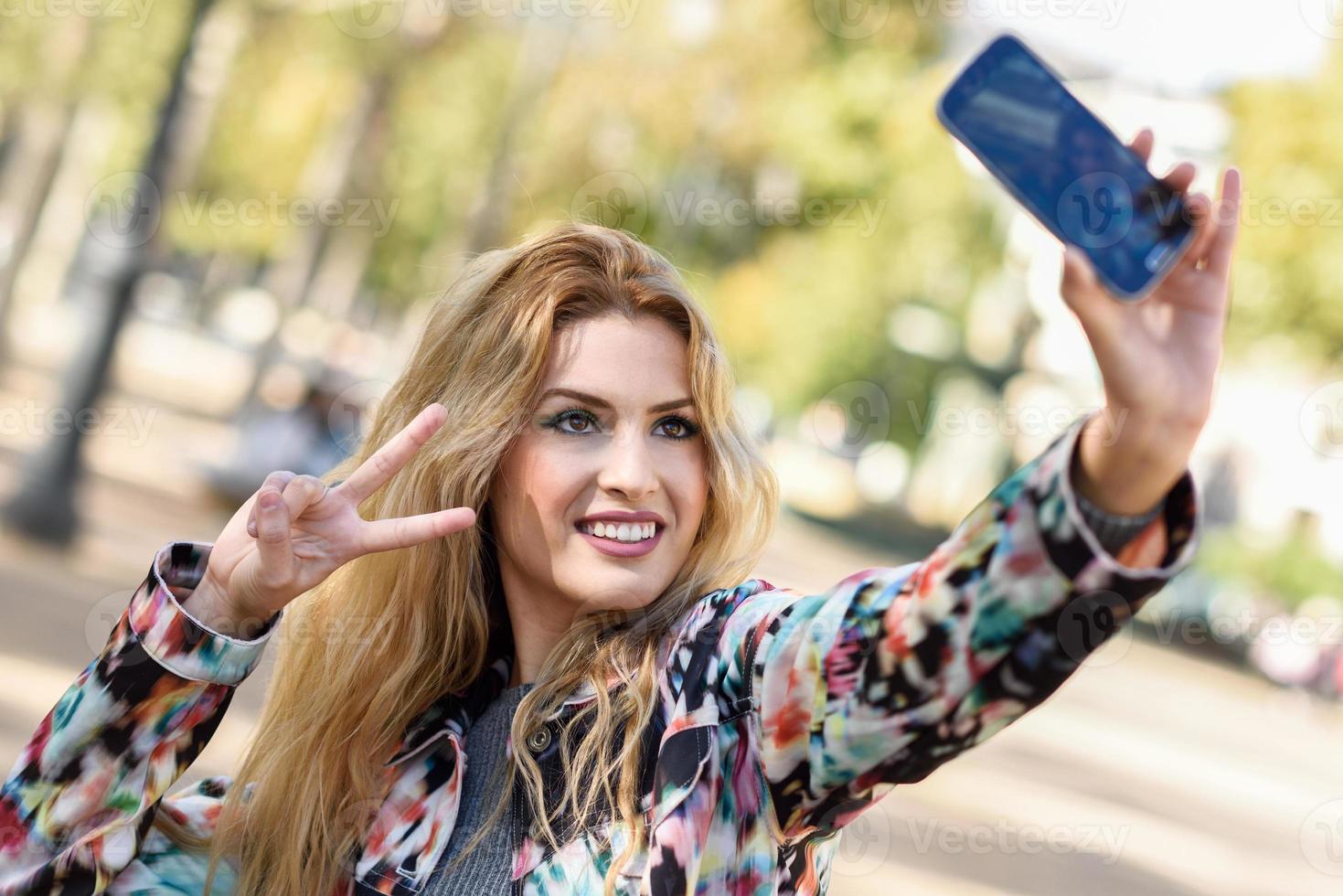 mooie jonge vrouw selfie in het park foto