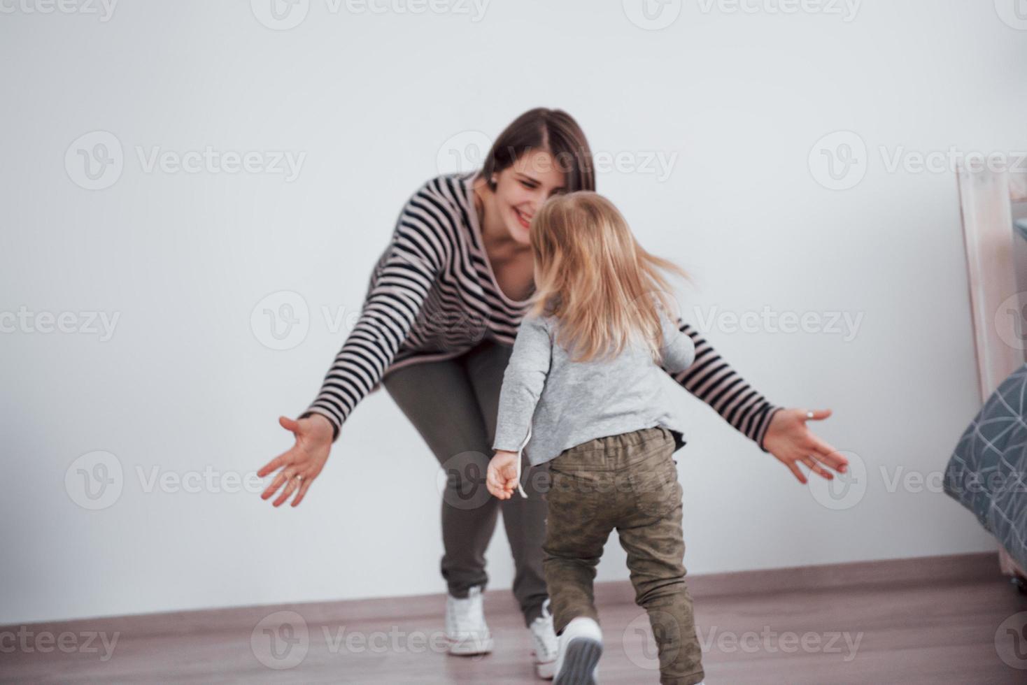 gelukkige liefdevolle familie. moeder en haar dochter kind meisje spelen en knuffelen foto