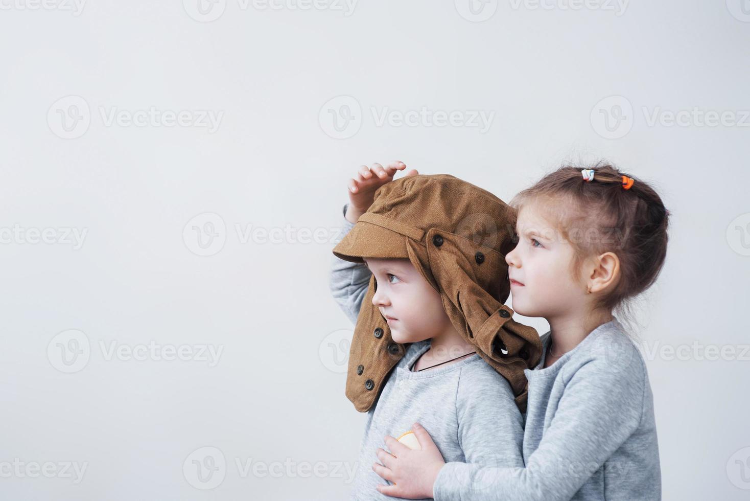 speelse jeugd. kleine jongen met plezier met kartonnen doos. jongen die zich voordoet als piloot. kleine jongen en meisje die plezier hebben thuis foto