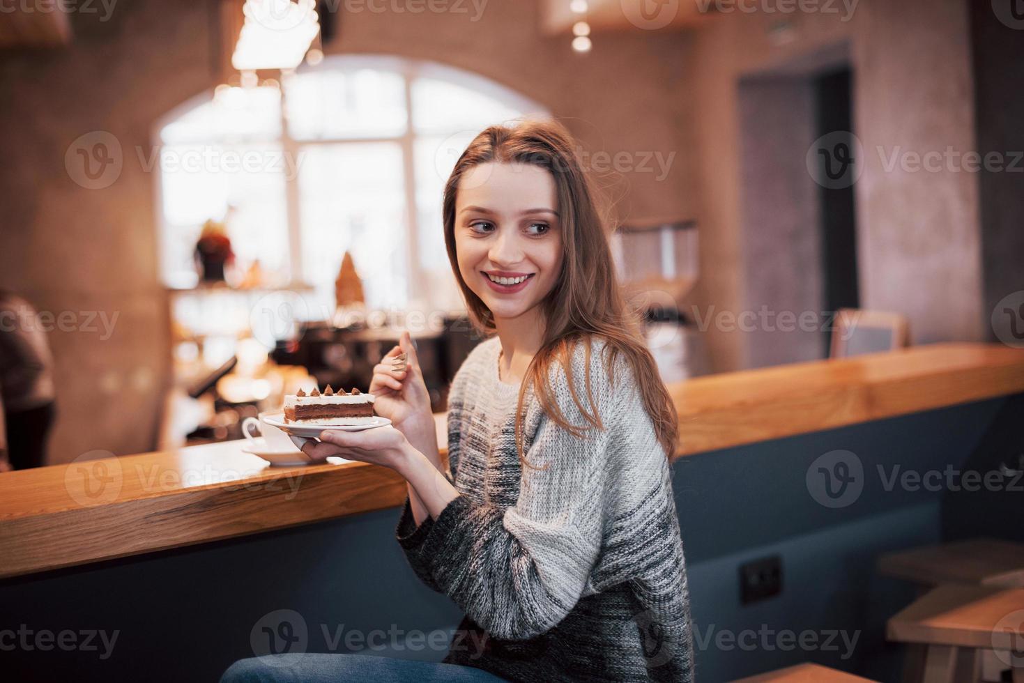 lachende vrouw in café met behulp van mobiele telefoon en sms'en in sociale netwerken, alleen zittend foto