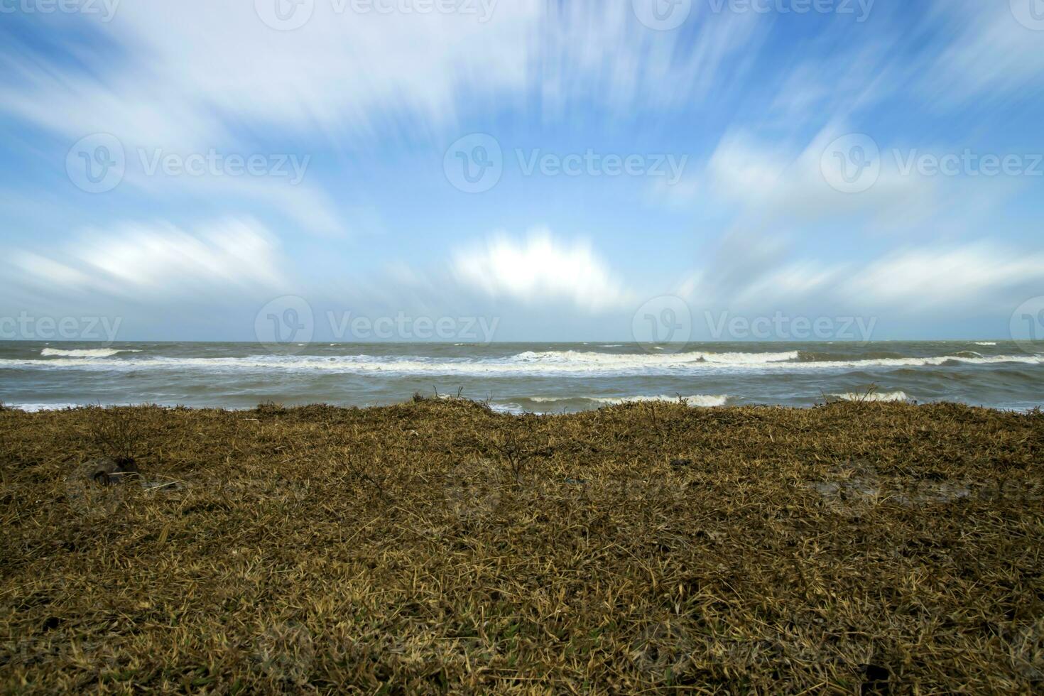 droog gras en beweging wolk over- de zee. foto