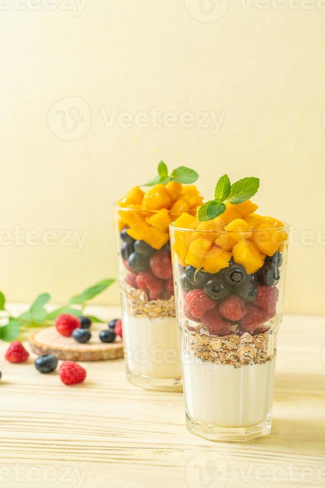 huisgemaakte mango, framboos en bosbes met yoghurt en granola foto