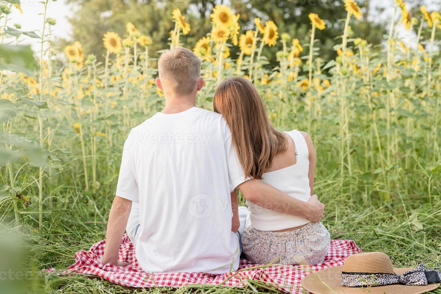 jong koppel knuffelen op een picknickdeken foto