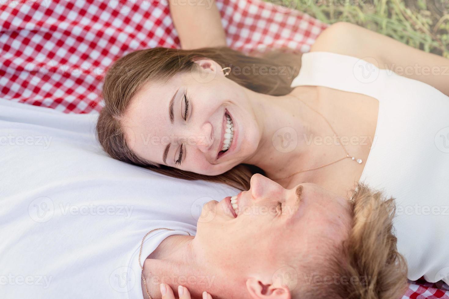 jong koppel knuffelen op een picknickdeken foto