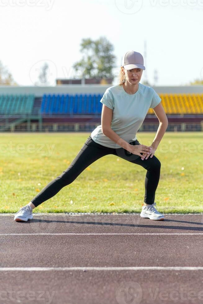 een jong mooi vrouw in sportkleding Toneelstukken sport- Bij een lokaal stadion foto