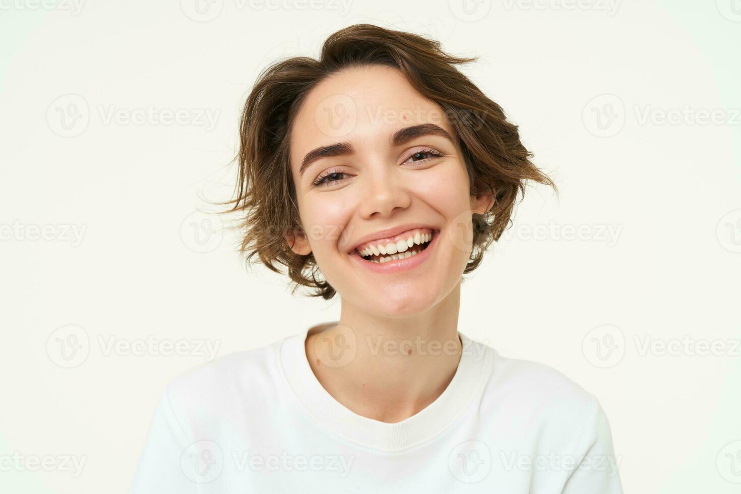 dichtbij omhoog portret van brunette vrouw lachend en lachend, uitdrukken oprecht emoties, poseren tegen wit studio achtergrond foto