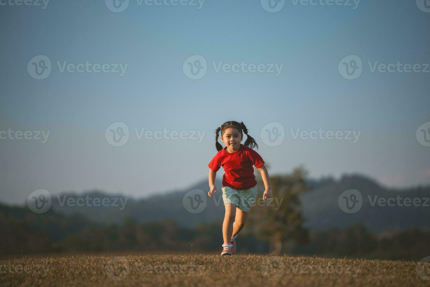 gelukkig baby Aziatisch meisje lachend. weinig meisje rennen en glimlachen Bij zonsondergang gelukkig baby meisje lachend. weinig baby rennen Bij zonsondergang. schattig baby rennen Bij speelplaats tuin. foto