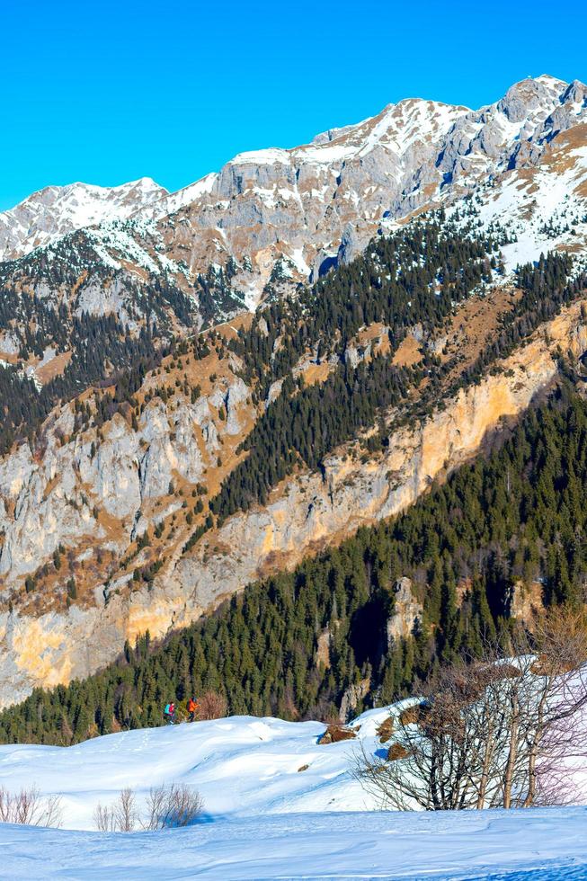 bergpanorama met twee klimmers in de verte in de sneeuw foto